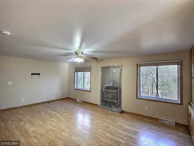 unfurnished living room featuring ceiling fan, light hardwood / wood-style floors, and a high end fireplace