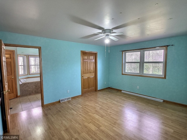 unfurnished bedroom featuring multiple windows, ceiling fan, a baseboard radiator, and light wood-type flooring