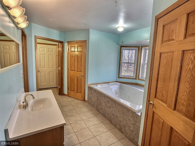 bathroom with tile patterned floors, tiled bath, and vanity