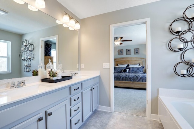 bathroom with vanity, tiled tub, and ceiling fan