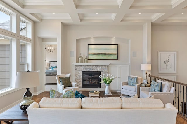 living room featuring crown molding, beam ceiling, a fireplace, and hardwood / wood-style floors