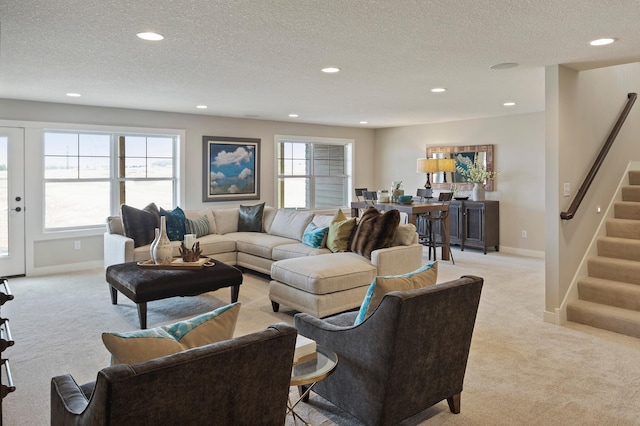 carpeted living room featuring a textured ceiling and plenty of natural light