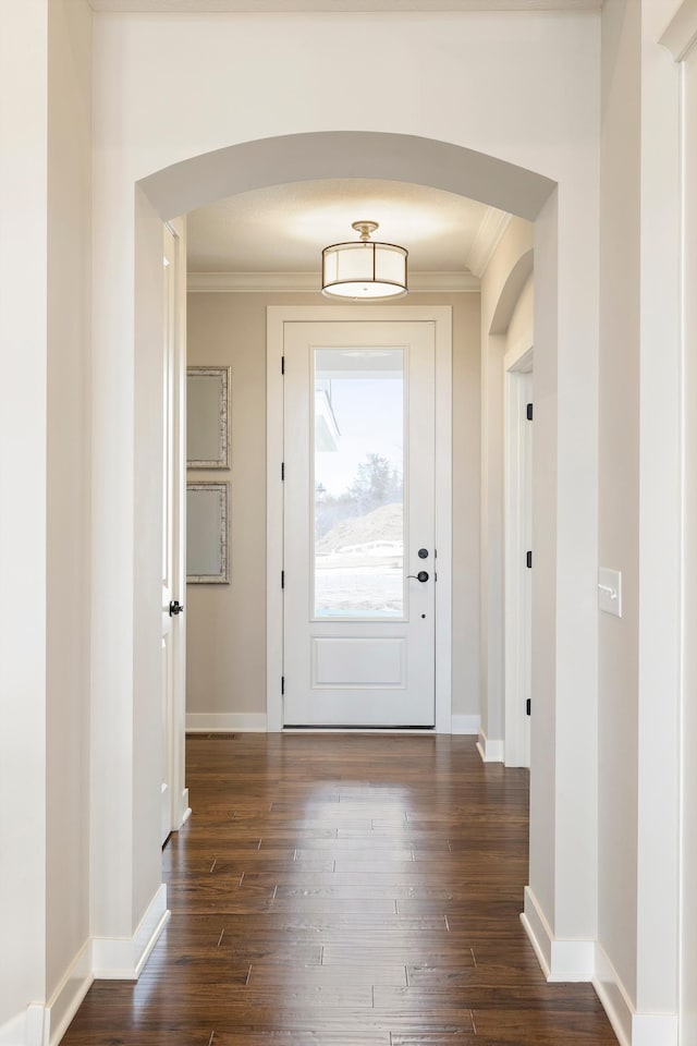 doorway to outside featuring crown molding and dark hardwood / wood-style flooring