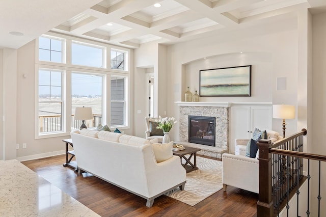 living room with dark wood-type flooring, beamed ceiling, a high ceiling, and a fireplace