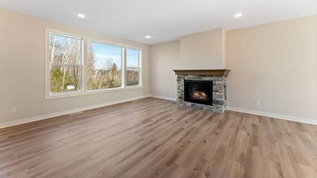 unfurnished living room featuring a fireplace and light hardwood / wood-style flooring