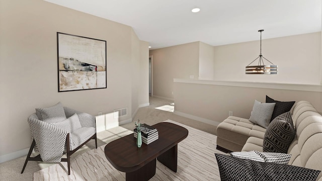 living room with light colored carpet and an inviting chandelier