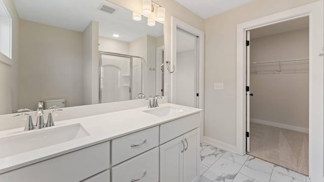 bathroom featuring toilet, a shower with door, and vanity