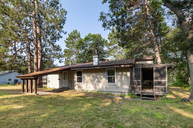 back of house with a yard, a carport, and a sunroom