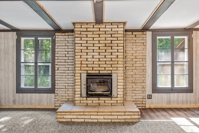 unfurnished living room with wood-type flooring, a wealth of natural light, and wood walls