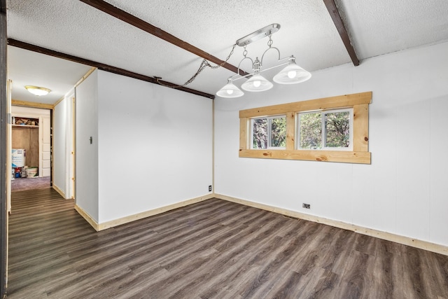 unfurnished dining area featuring a textured ceiling, dark wood-type flooring, and beamed ceiling