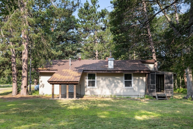 back of property featuring a yard and a sunroom