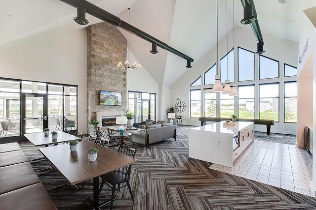 living room featuring high vaulted ceiling, billiards, a fireplace, beam ceiling, and a chandelier