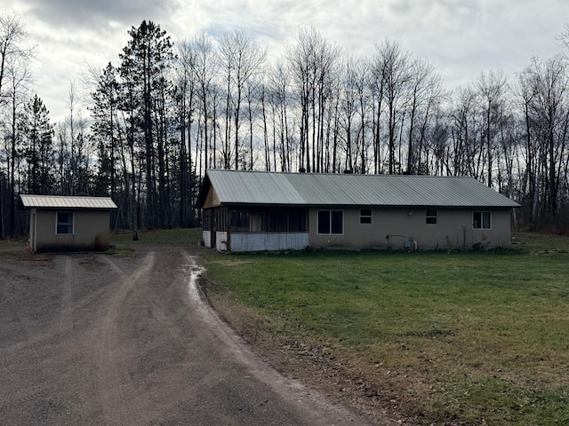 view of front of house with a front yard and a storage unit