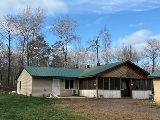 view of front of house featuring a sunroom and a front yard