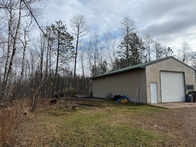 view of outbuilding featuring a lawn and a garage