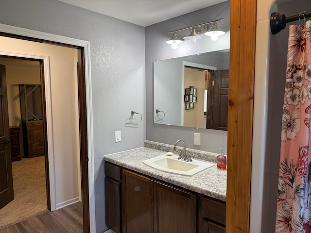 bathroom with hardwood / wood-style floors, a shower with shower curtain, and vanity