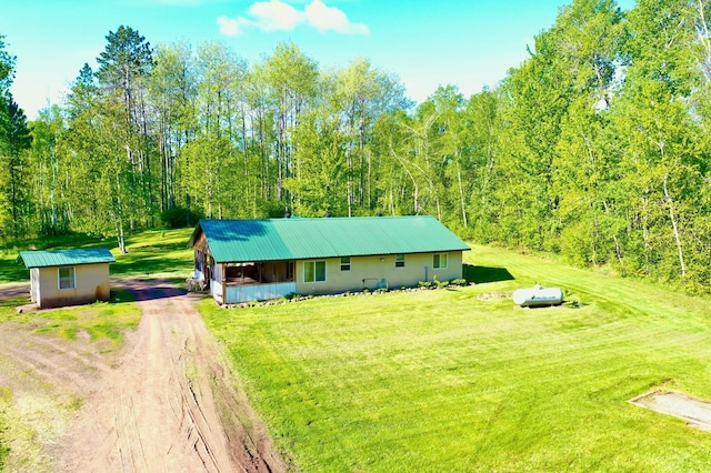 41574 Koland Rd, Sandstone Twp, MN 55072 - view of front of home featuring dirt driveway, a front yard, metal roof, an outbuilding, and a view of trees