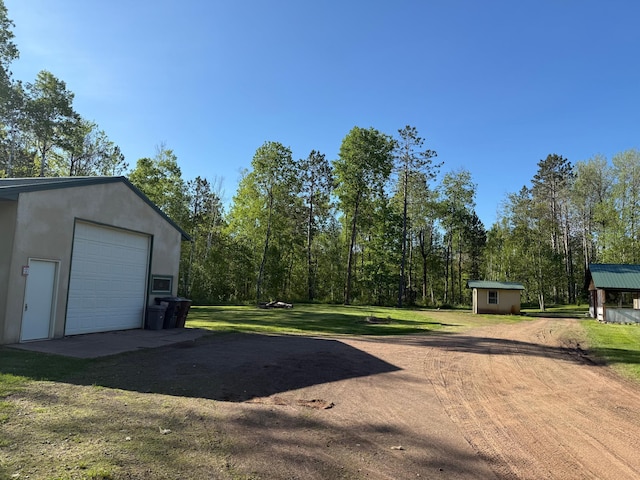 41574 Koland Rd, Sandstone Twp, MN 55072 - view of green lawn with dirt driveway, an outbuilding, and a garage
