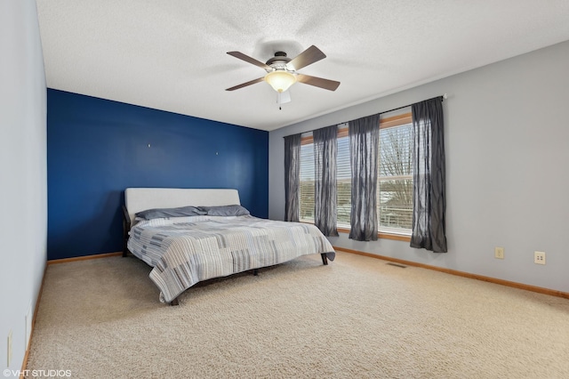 bedroom featuring ceiling fan, carpet flooring, and a textured ceiling