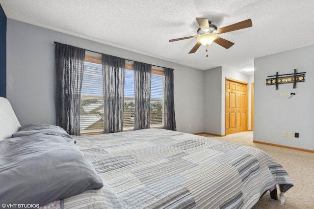 bedroom featuring ceiling fan, light carpet, and a textured ceiling