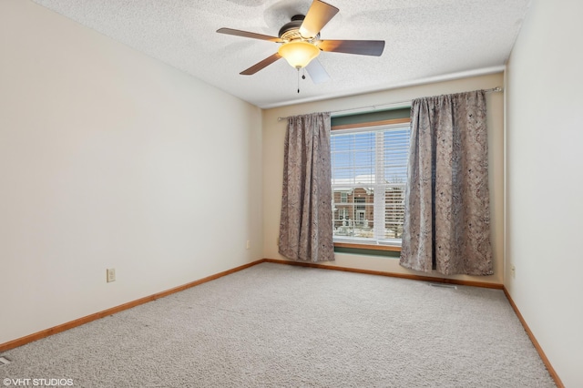 carpeted empty room featuring ceiling fan and a textured ceiling