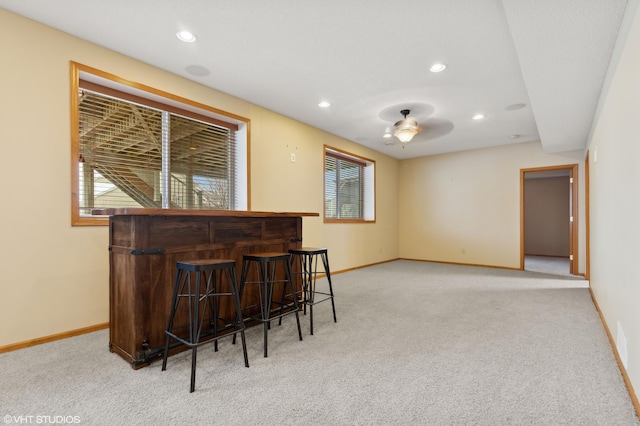 bar featuring ceiling fan and light carpet