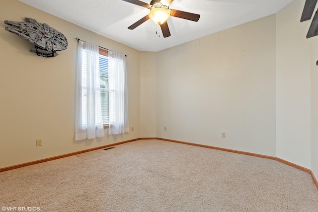 spare room featuring ceiling fan and carpet