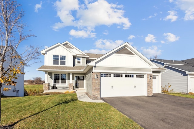 craftsman-style home featuring covered porch, a garage, and a front yard