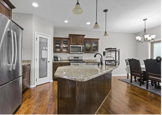 kitchen featuring dark hardwood / wood-style flooring, dark brown cabinets, decorative light fixtures, and appliances with stainless steel finishes