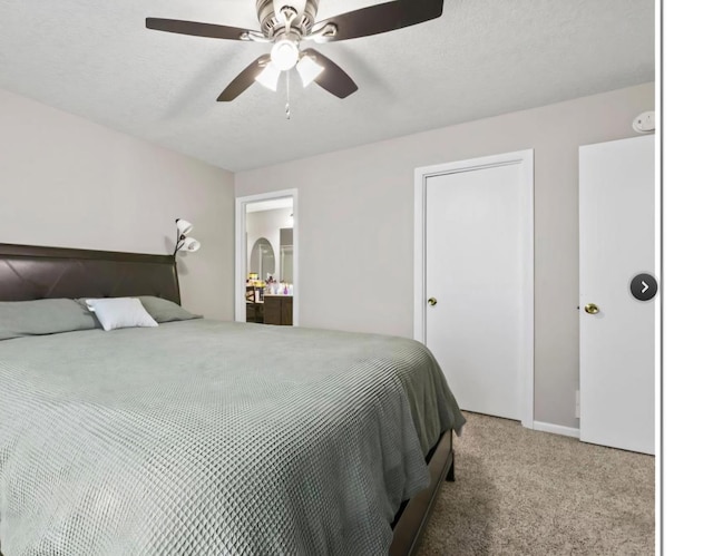 carpeted bedroom featuring connected bathroom, a textured ceiling, and ceiling fan