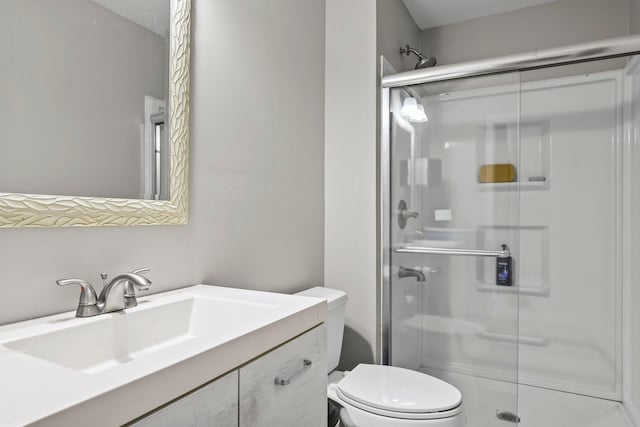 bathroom featuring walk in shower, vanity, and toilet