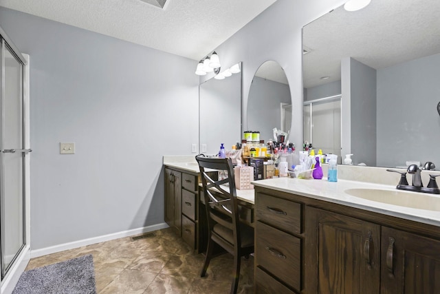 bathroom featuring vanity, a textured ceiling, tile patterned floors, and an enclosed shower