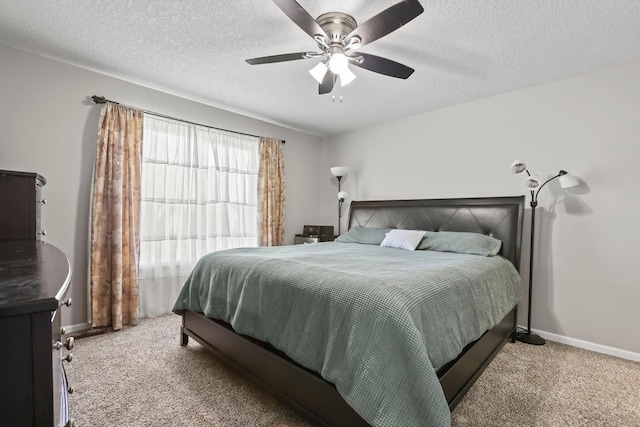 carpeted bedroom with ceiling fan and a textured ceiling