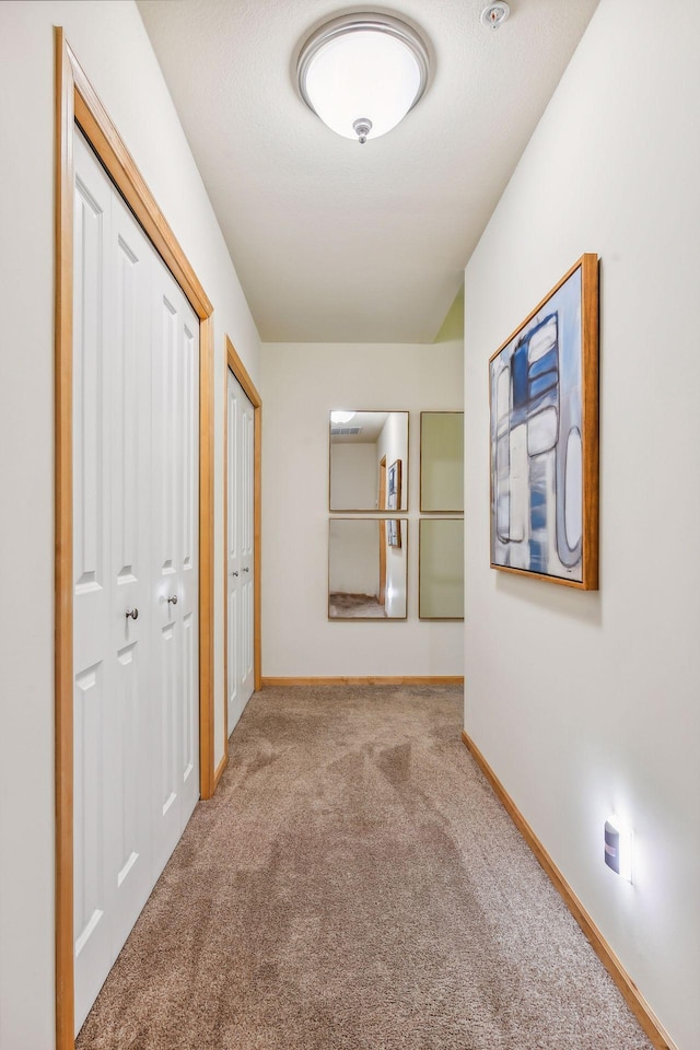 hall featuring light colored carpet