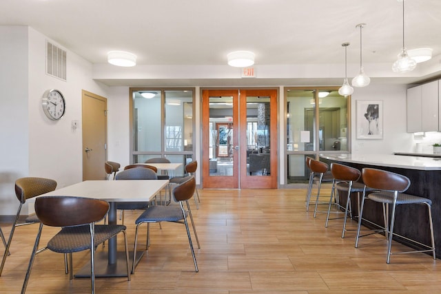 dining area featuring french doors and light hardwood / wood-style flooring