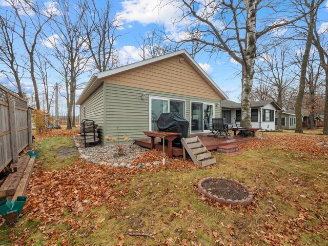 rear view of property with a deck and a lawn