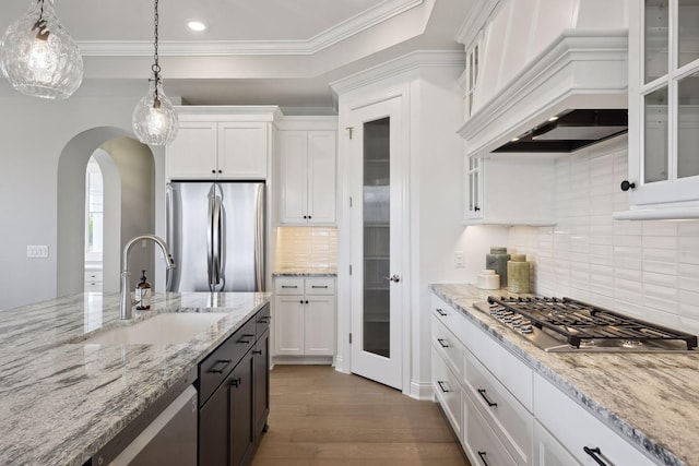 kitchen with stainless steel appliances, sink, decorative light fixtures, light wood-type flooring, and white cabinets