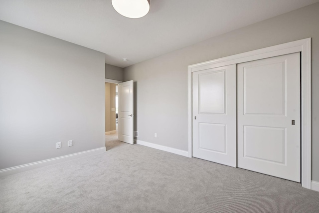 unfurnished bedroom with light carpet and a closet