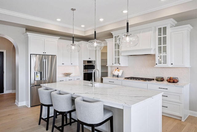9155 Mills Dr, Chanhassen, MN 55317 - kitchen with arched walkways, baseboards, white cabinetry, and appliances with stainless steel finishes