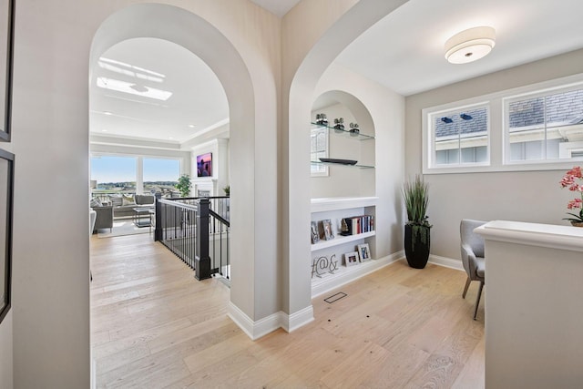9155 Mills Dr, Chanhassen, MN 55317 - corridor featuring wood finished floors, an upstairs landing, built in features, arched walkways, and baseboards