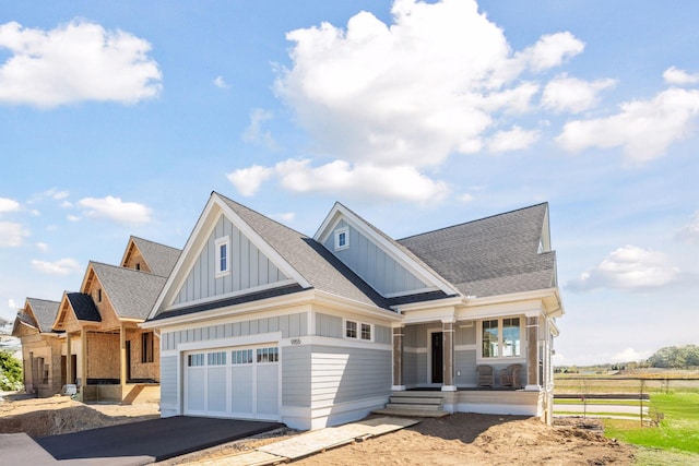 9155 Mills Dr, Chanhassen, MN 55317 - view of front of house with a porch, driveway, a garage, board and batten siding, and a shingled roof