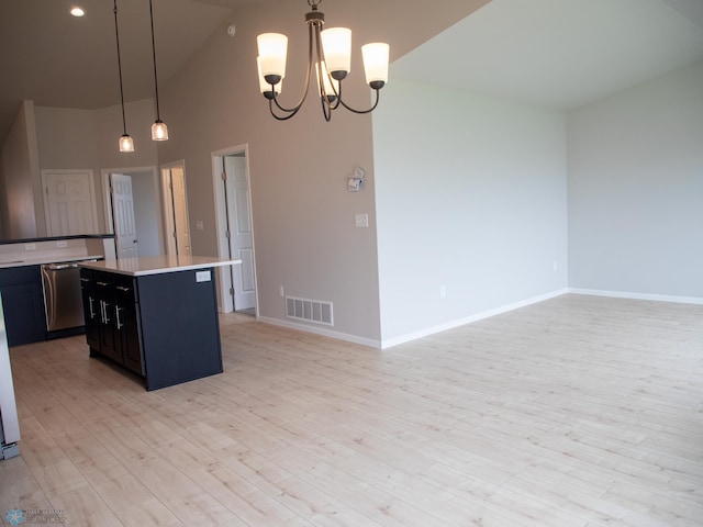 kitchen with pendant lighting, high vaulted ceiling, light hardwood / wood-style floors, a notable chandelier, and a kitchen island