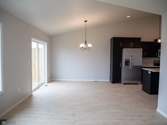 kitchen with light hardwood / wood-style flooring, a chandelier, lofted ceiling, and appliances with stainless steel finishes