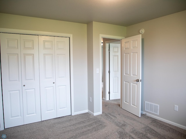 unfurnished bedroom featuring a closet and light colored carpet