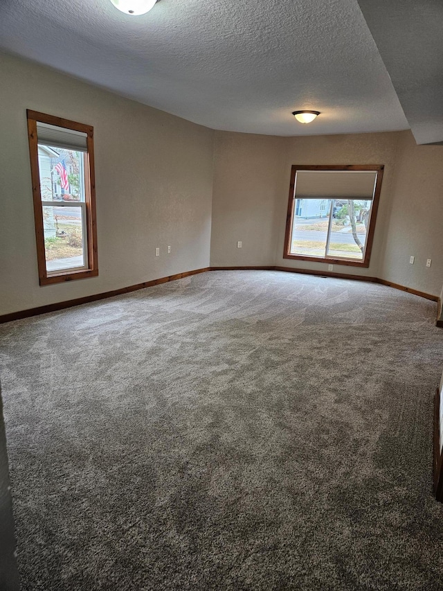 carpeted empty room with a textured ceiling