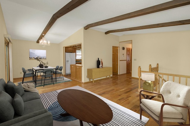 living room featuring lofted ceiling with beams, an inviting chandelier, and light hardwood / wood-style flooring