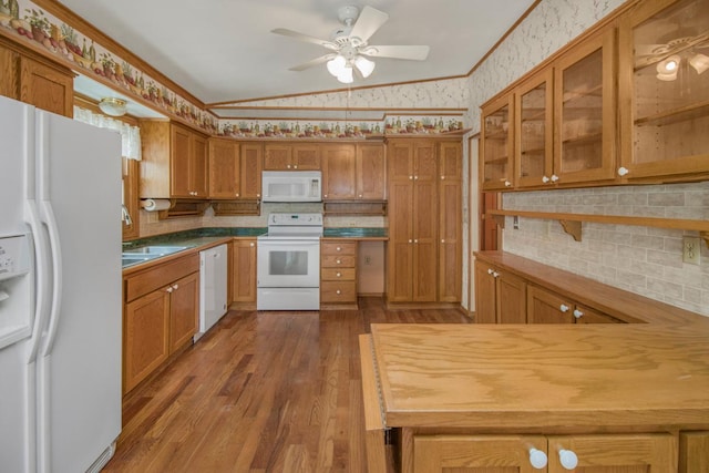 kitchen featuring lofted ceiling, sink, white appliances, dark wood-type flooring, and crown molding