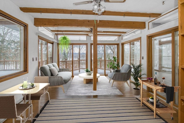 sunroom / solarium featuring beamed ceiling, a wealth of natural light, and ceiling fan