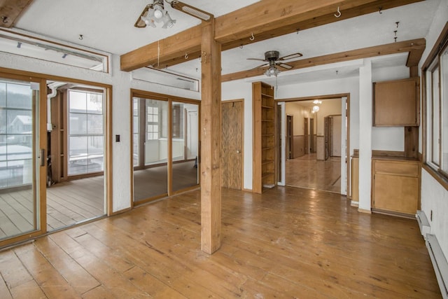 unfurnished room with ceiling fan, beam ceiling, hardwood / wood-style floors, and a baseboard radiator