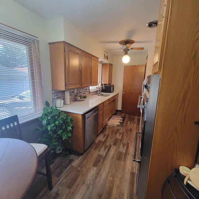 kitchen with sink, ceiling fan, stainless steel dishwasher, dark wood-type flooring, and decorative backsplash